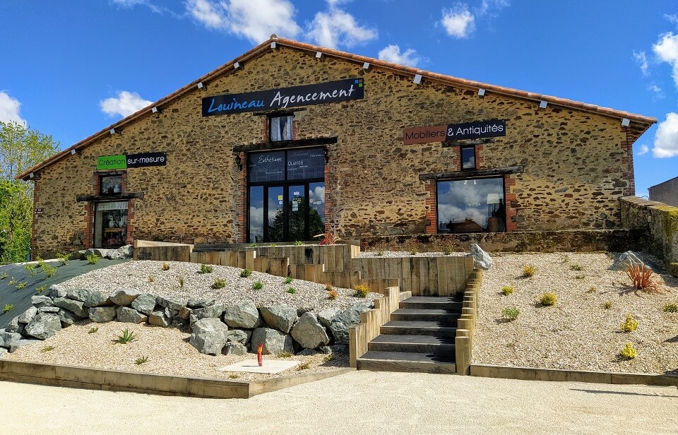 Façade du magasin Louineau Agencement aux Essarts en Bocage en Vendée : Vente d'antiquités et magasin de meubles.